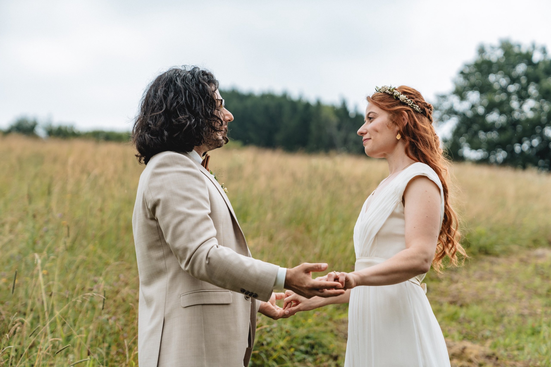 Erster Blick auf die Braut im weißen Kleid mit Blumenkranz