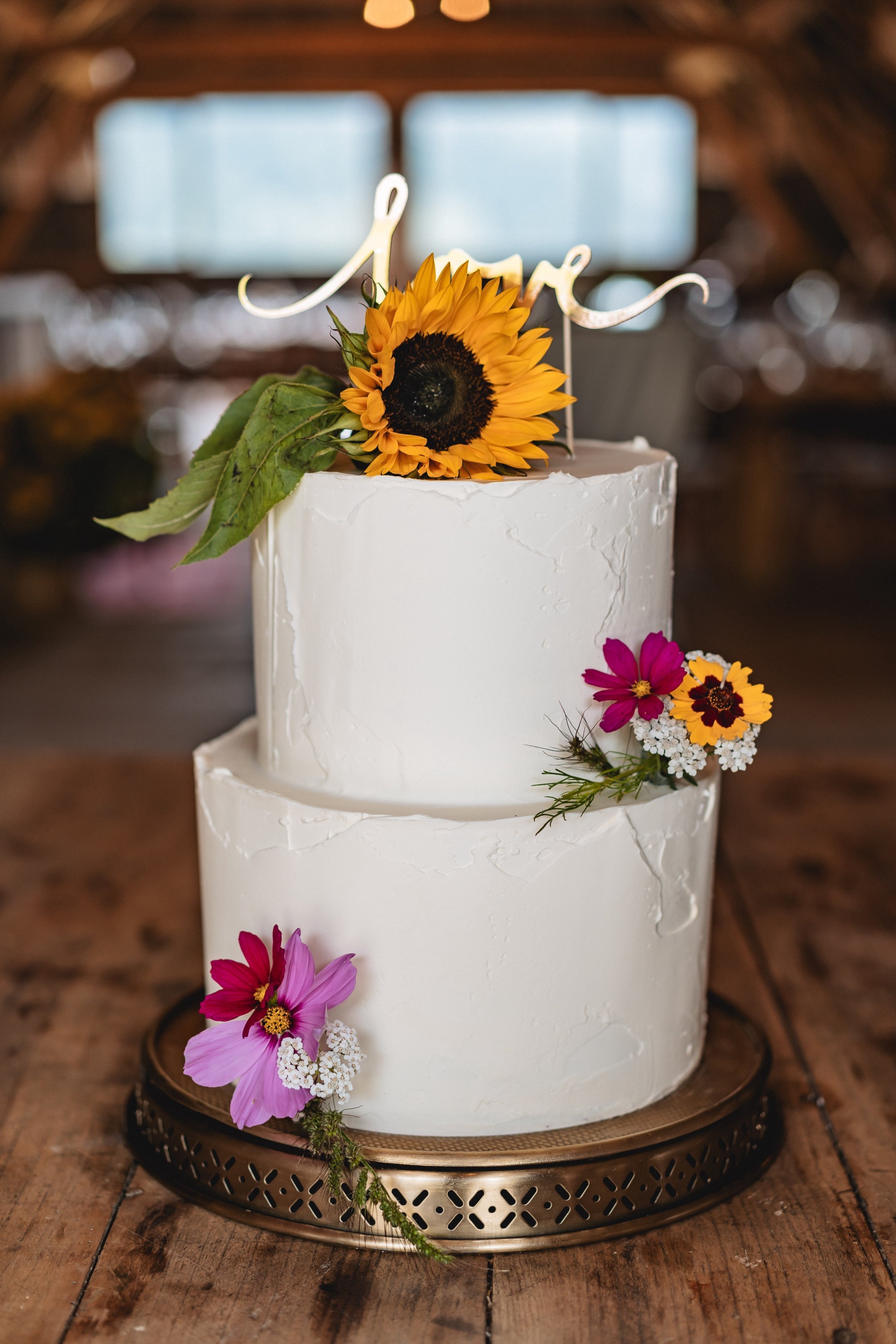 Zweistöckige Hochzeitstorte mit Sonnenblume und Wiesenblumen