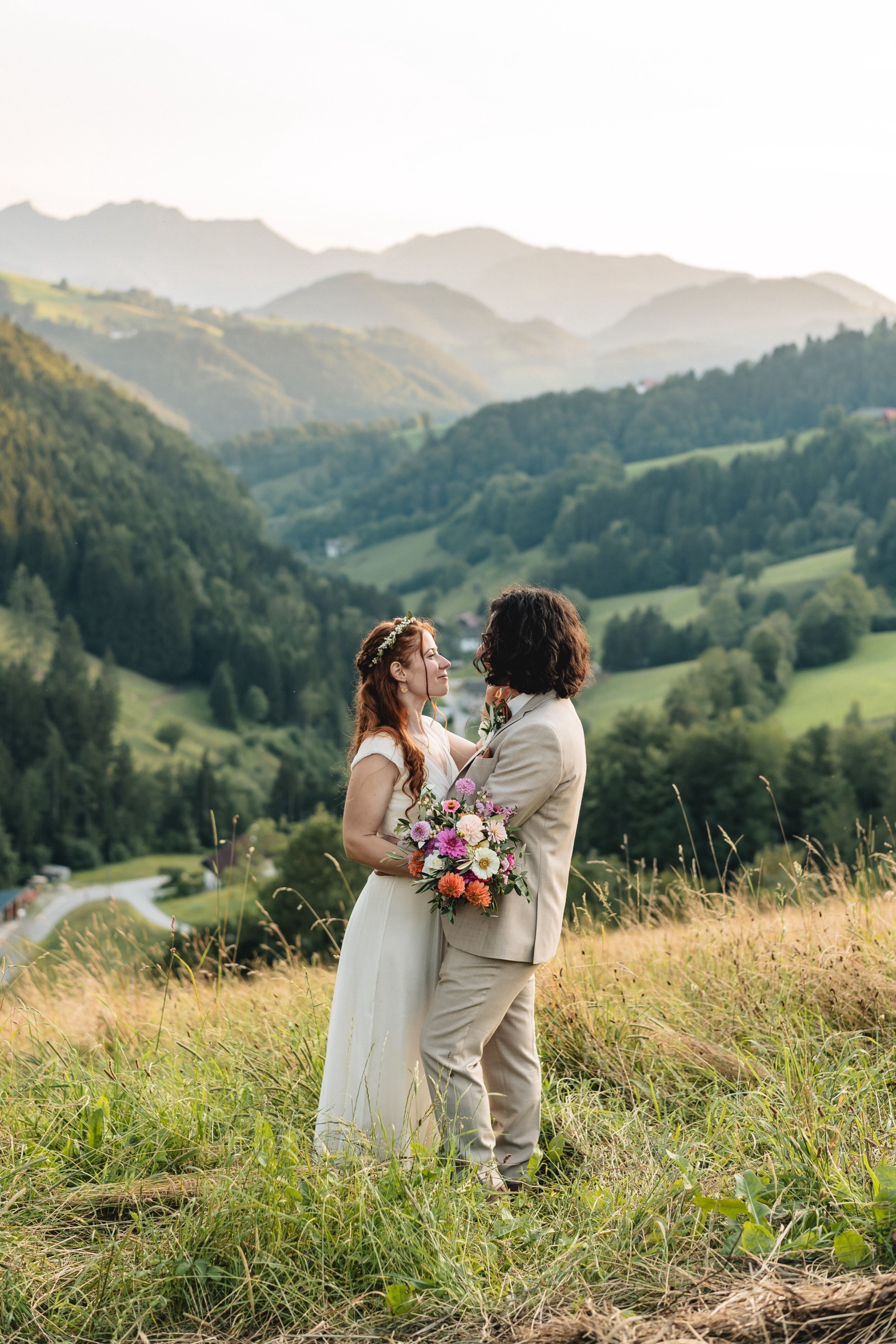 Hochzeitspaar vor den Bergen des Voralpenlandes am Abend