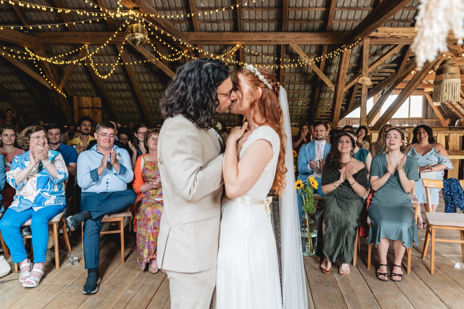 Hochzeitskuss bei der freien Trauung, die Gäste applaudieren