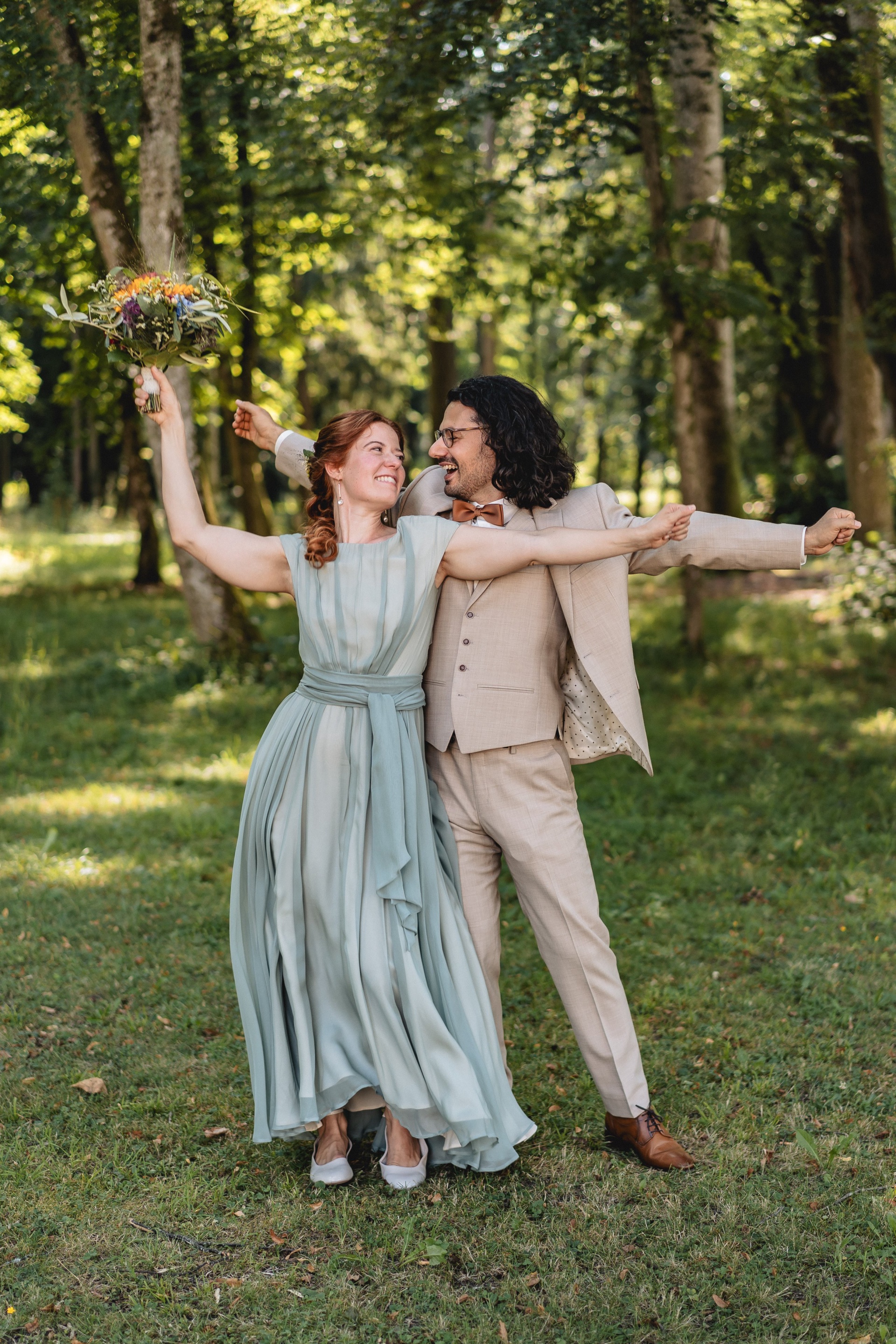 Ausgelassener Moment im Park, Hannah reckt den Brautstrauß in die Höhe